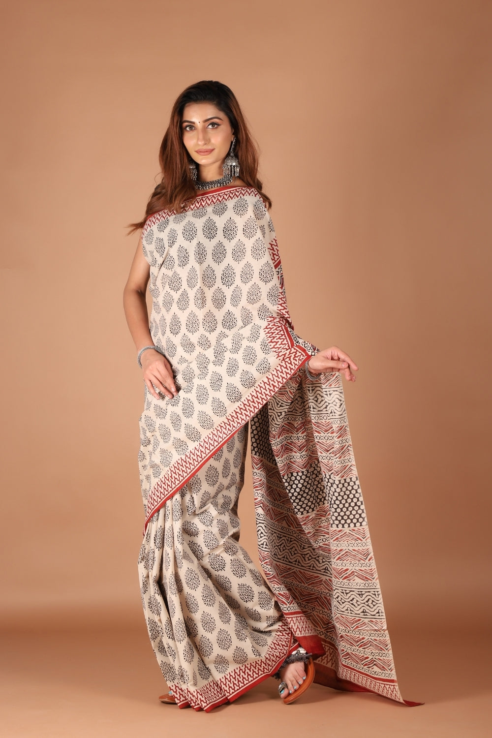 Beige mull cotton saree with black hand block prints and rust red border