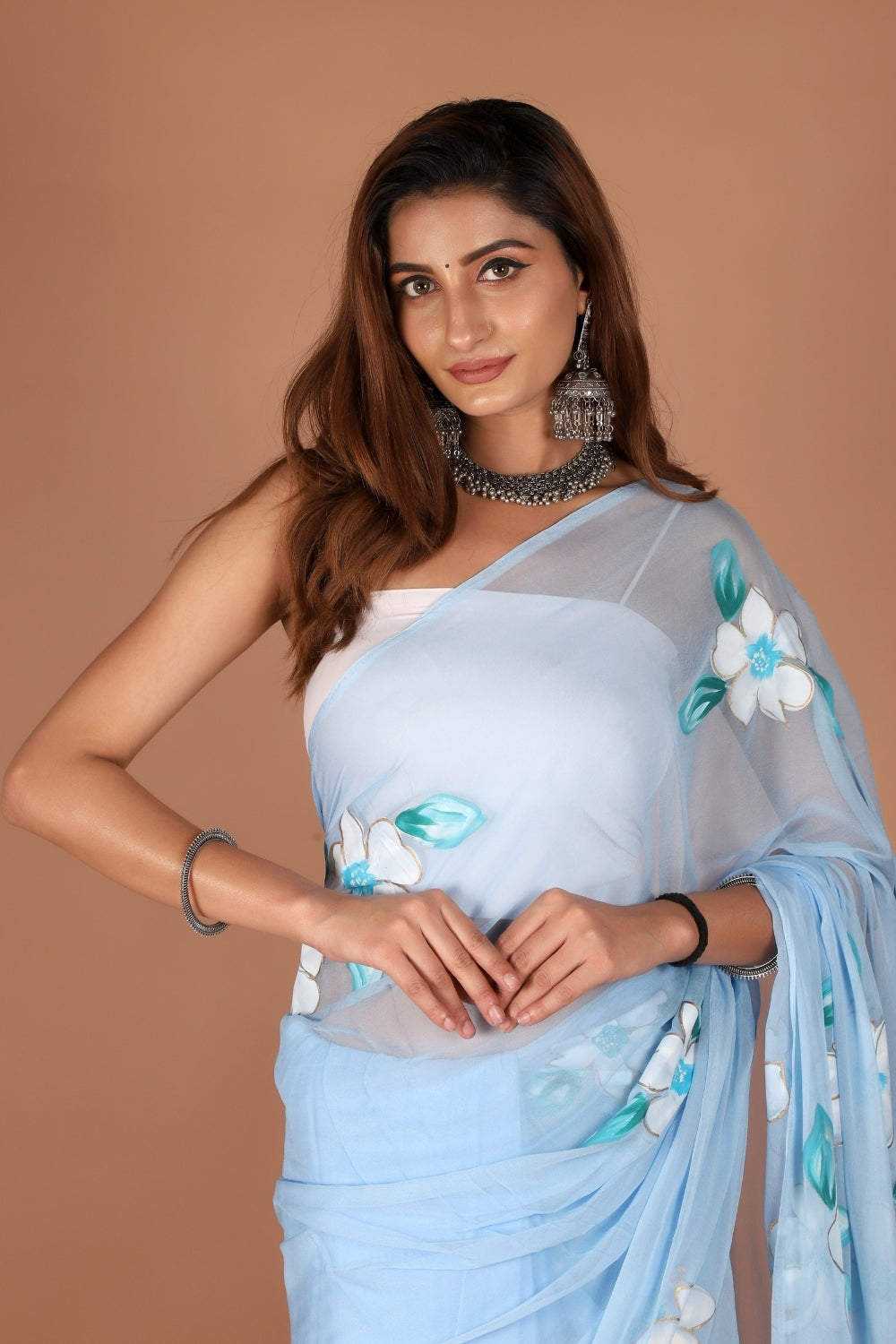 Model in sky blue chiffon saree with hand-painted white flowers