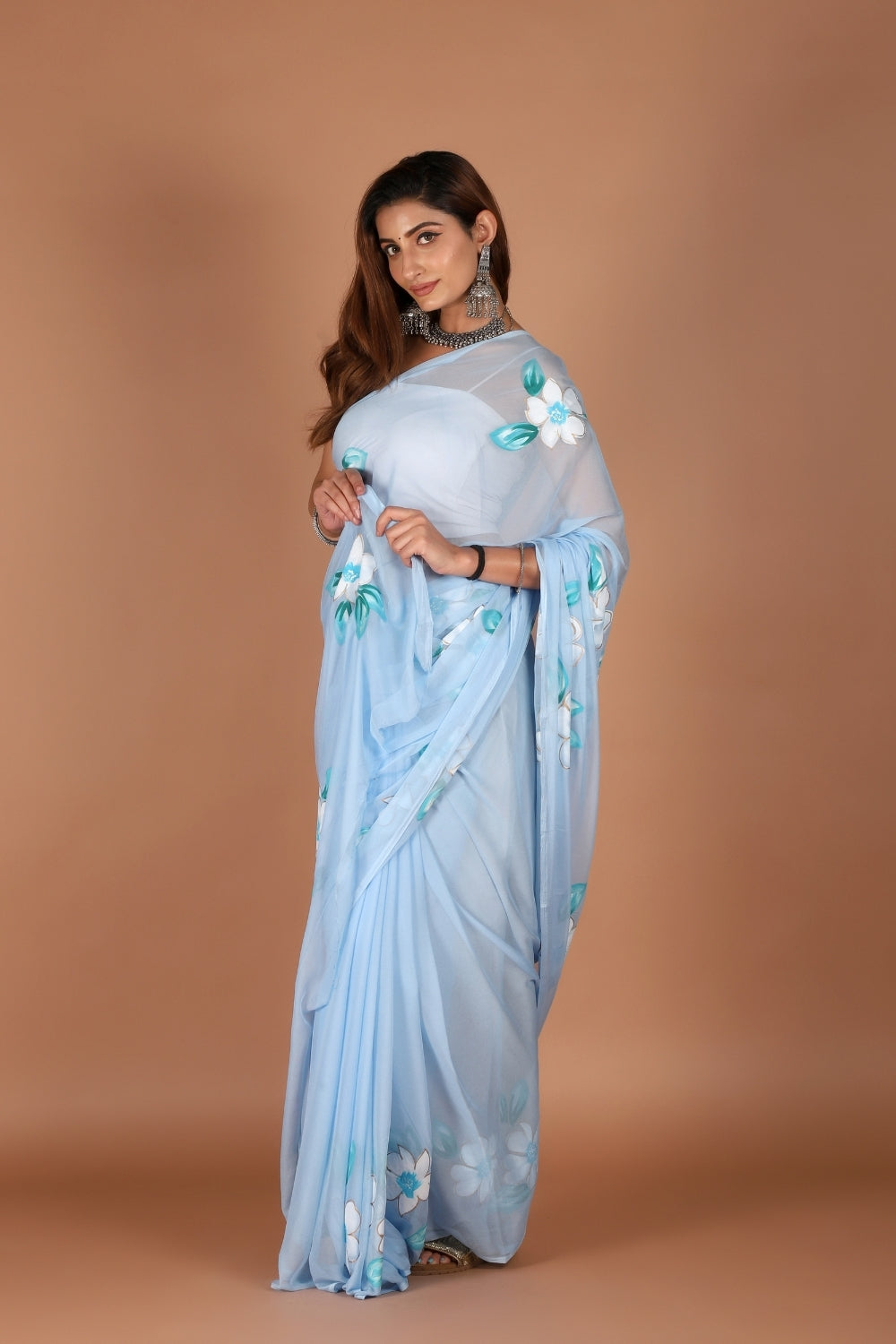 Model in sky blue chiffon saree with hand-painted white flowers