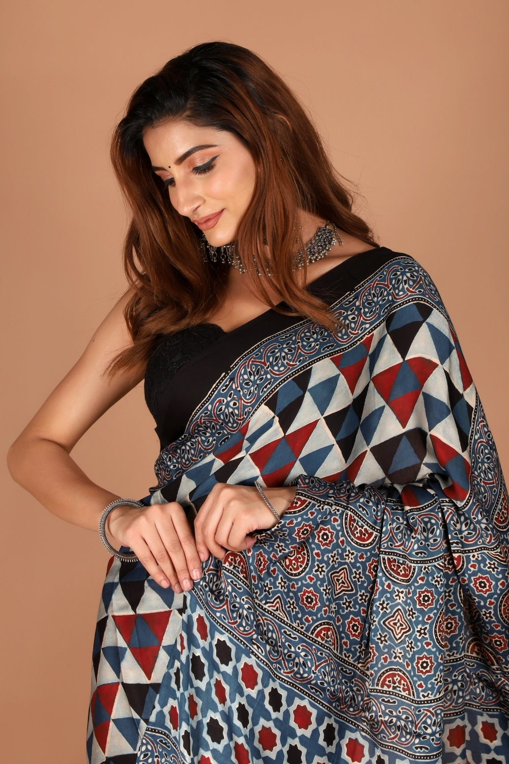 Woman draped in black modal silk Ajrakh saree with zari palla