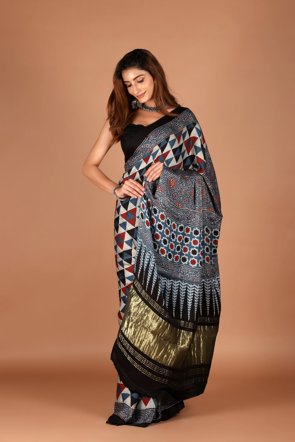 Woman draped in black modal silk Ajrakh saree with zari palla