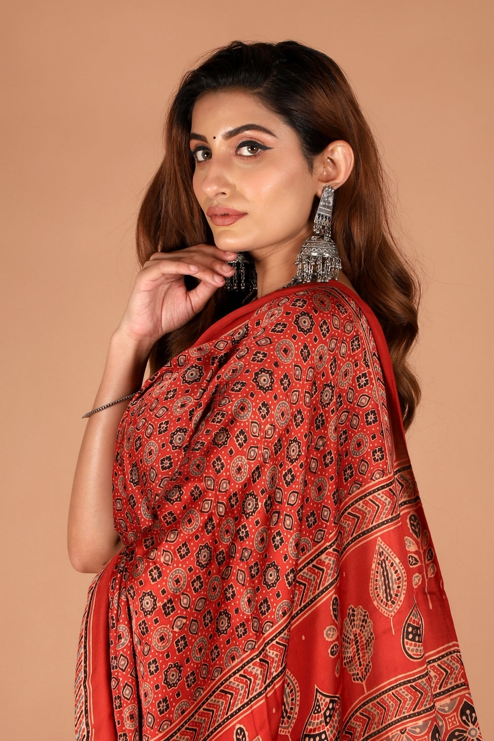 Model in red Ajrakh modal silk saree with shimmering zari palla