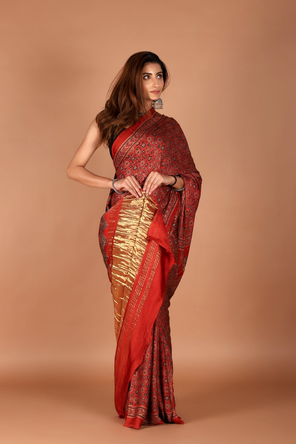 Model in red Ajrakh modal silk saree with shimmering zari palla