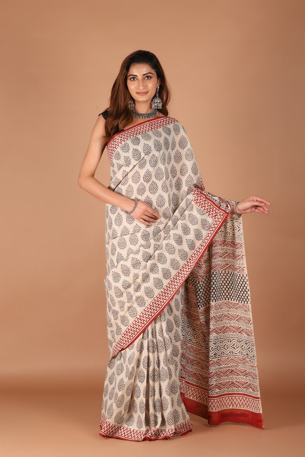 Beige mull cotton saree with black hand block prints and rust red border
