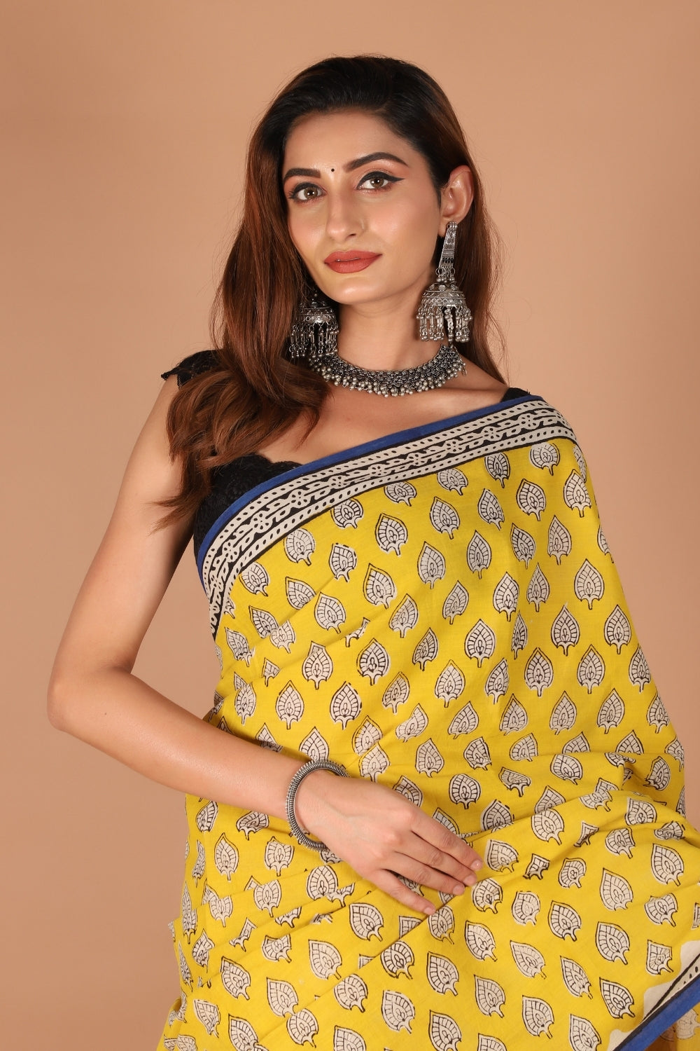 Model wearing yellow hand block printed pure mull cotton saree with indigo border