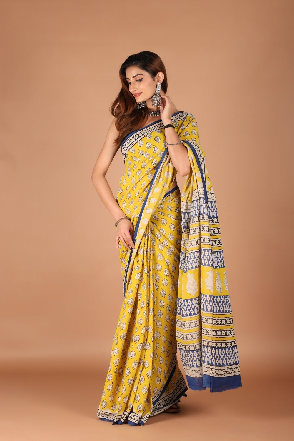 Model wearing yellow hand block printed pure mull cotton saree with indigo border