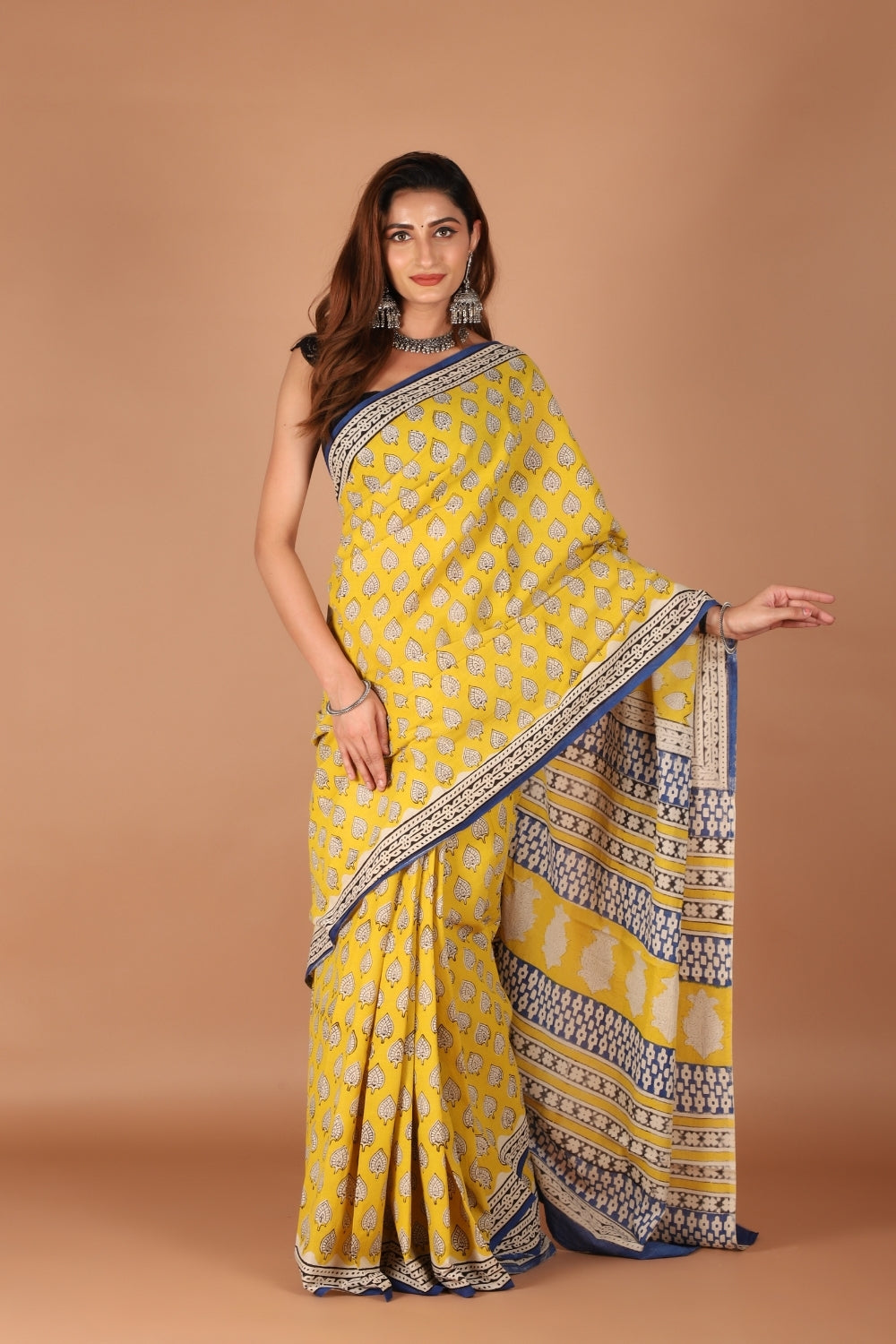 Model wearing yellow hand block printed pure mull cotton saree with indigo border